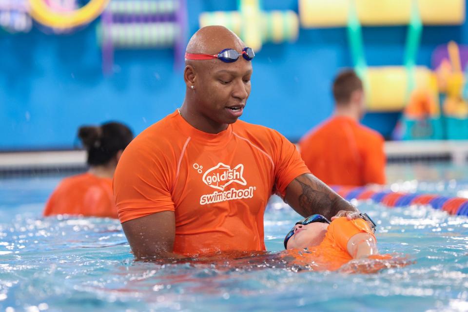 Olympic swimmer Cullen Jones works with a student during his visit at the Goldfish Swim School in Milford, Dec. 2, 2023.