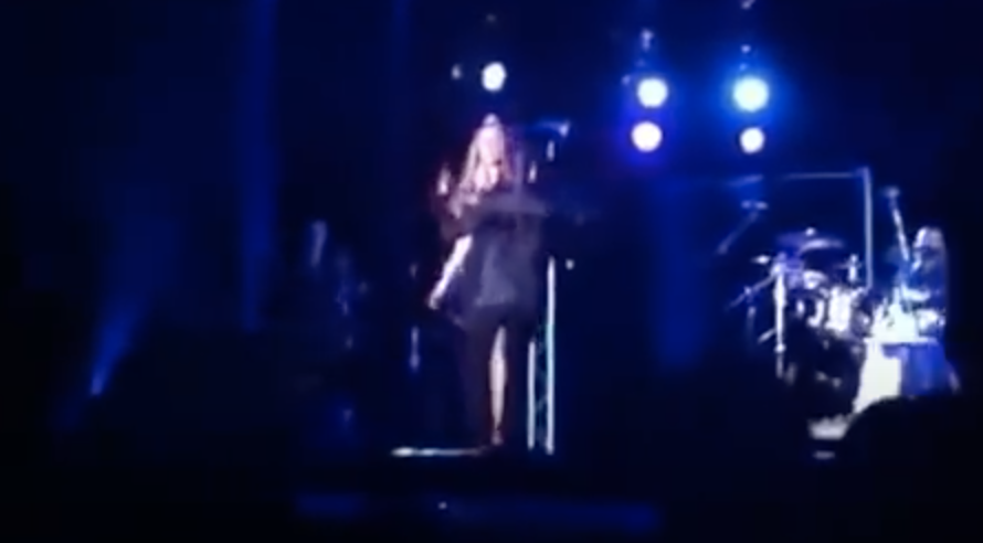 Blurry image of Mariah being hugged by someone onstage