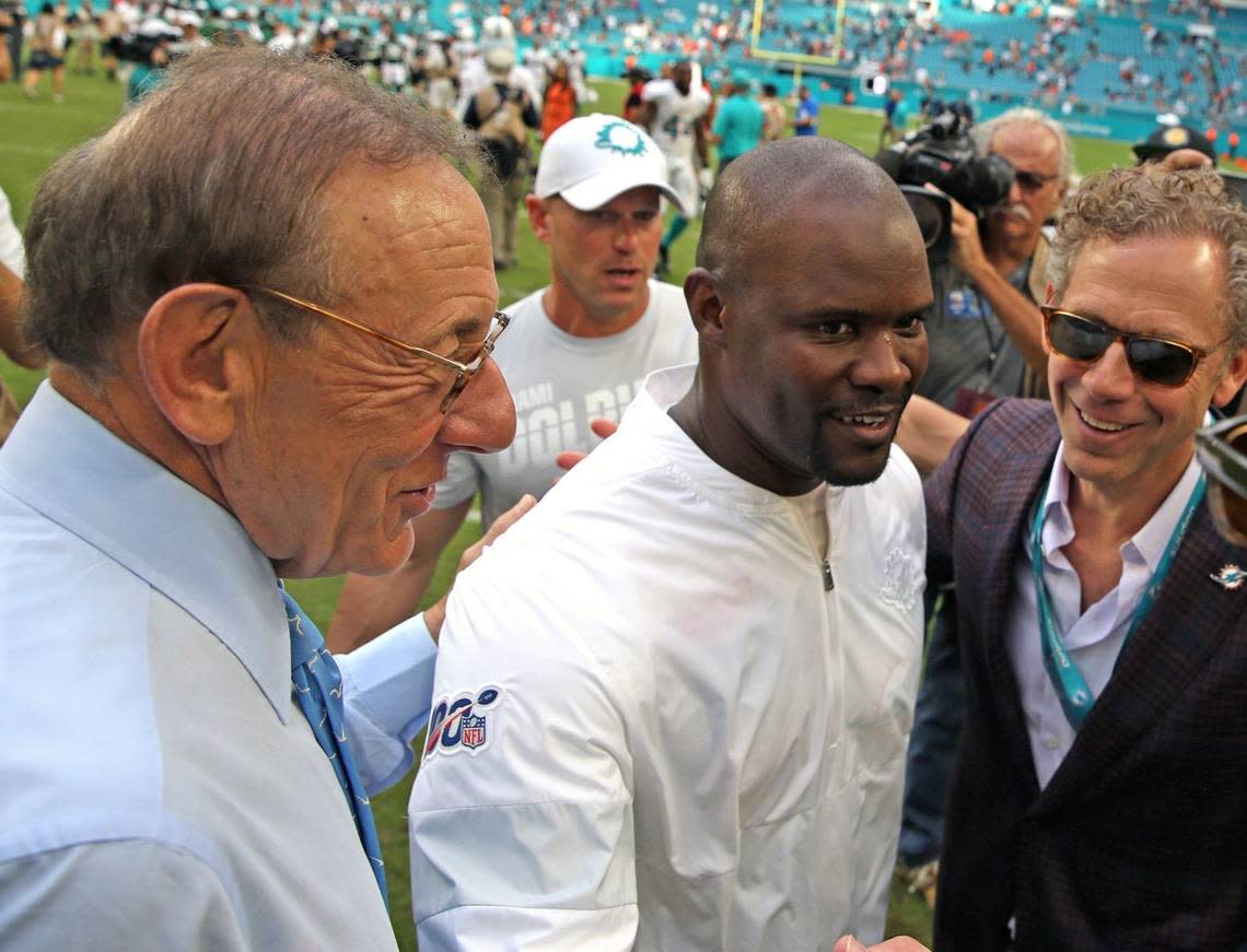 Miami Dolphins owner Stephen Ross, left, and Dolphins owner-in-waiting Bruce Beal, right, congratulate coach Brian Flores in happier days. Ross unexpectedly fired Flores after three seasons.