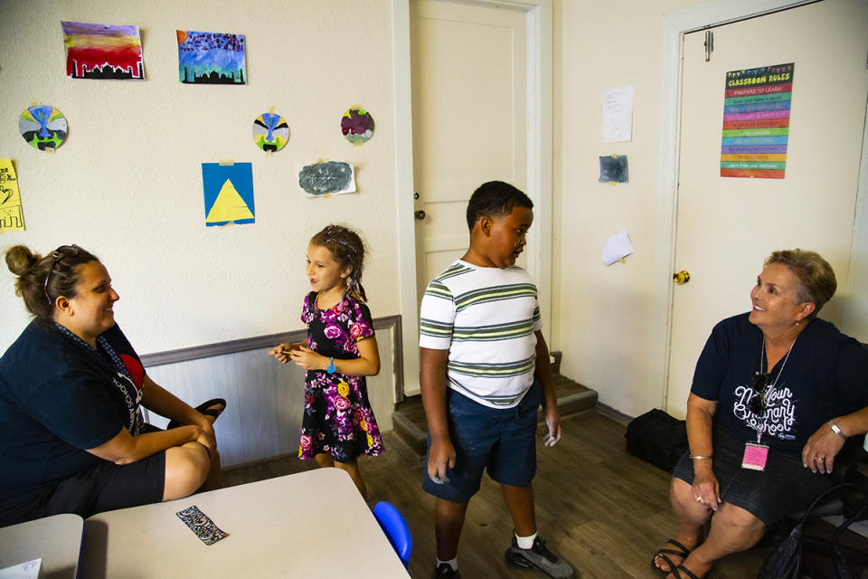 NYOS students catch up with Samantha Gladwell, NYOS Charter School elementary assistant principal (left), and school Principal Terry Berkenhoff (right) during a summer camp that gives Austin kids extra learning time. (Emmeline Zhao for The 74)