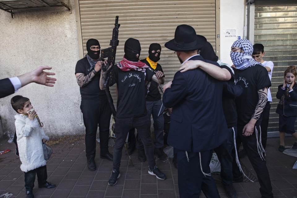 Ultra-Orthodox Jews dress in ISIS militants costumes during celebrations of the Jewish festival of Purim in Bnei Brak, Israel, Tuesday, March 10, 2020. The Jewish holiday of Purim commemorates the Jews' salvation from genocide in ancient Persia, as recounted in the Book of Esther. (AP Photo/Oded Balilty)