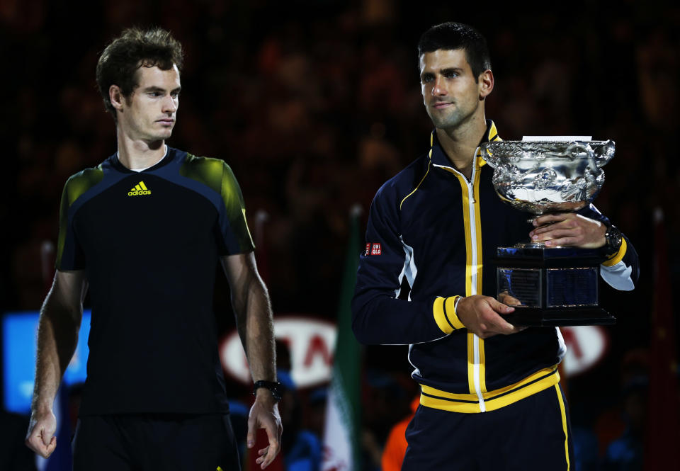 Runner-up Andy Murray of Britain (L) looks on as Novak Djokovic of Serbia poses with the Norman Brookes Challenge Cup after their men's singles final match at the Australian Open tennis tournament in Melbourne January 27, 2013. REUTERS/Damir Sagolj (AUSTRALIA - Tags: SPORT TENNIS) - RTR3D18Y