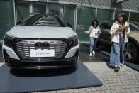 Women look at an Audi Q5 e-tron electric vehicle displayed at a Volkswagen event ahead of the auto show in Beijing, Wednesday, April 24, 2024. Foreign automakers have been caught flat-footed in China by an electric vehicle boom that has shaken up the market over the last three years. That has left manufacturers like Volkswagen scrambling to develop new models for a very different market than at home. (AP Photo/Ng Han Guan)