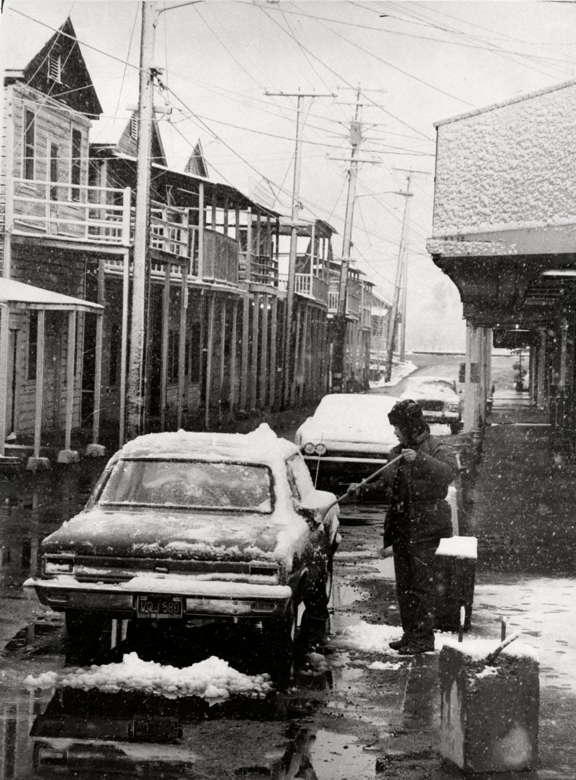 Dustin Marr sweeps accumulated snow from his car in Locke on Feb. 5, 1976. Skip Shuman/Sacramento Bee file