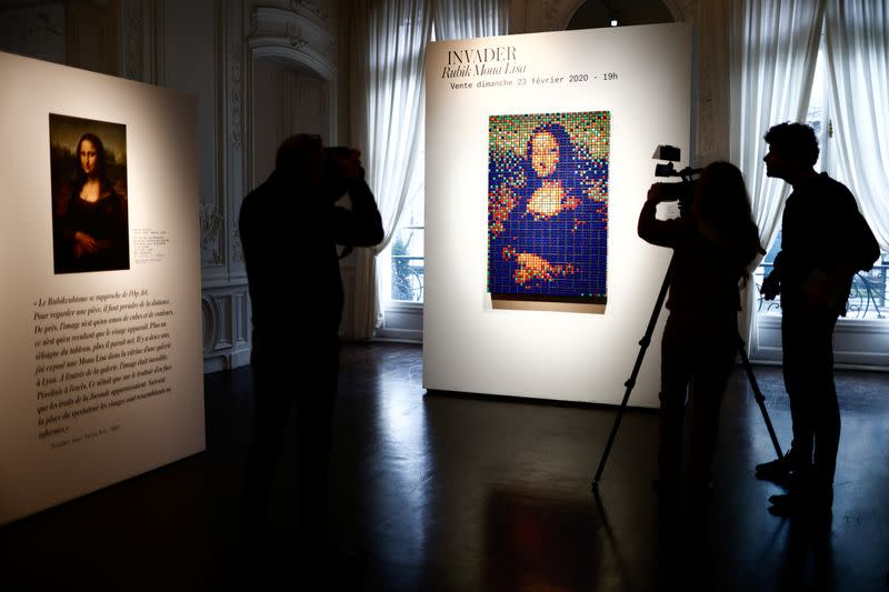 Journalists work next to the Rubik Mona Lisa (2005) by French street artist Invader displayed at ArtCurial in Paris