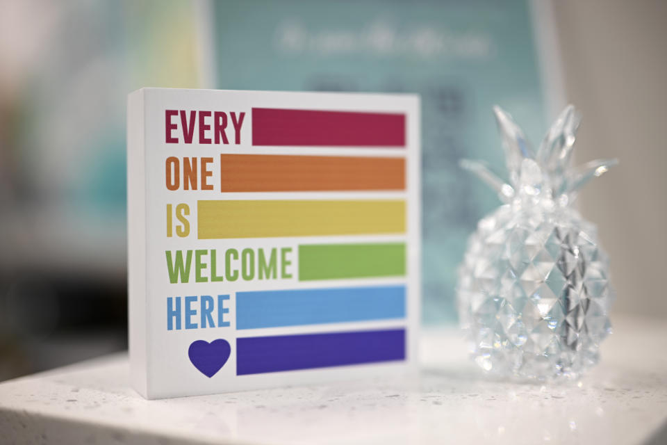 A sign supporting the LGBTQ+ community is displayed at the reception desk at the Pineapple Healthcare medical clinic in Orlando, Fla., on May 28, 2024. (AP Photo/Phelan M. Ebenhack)