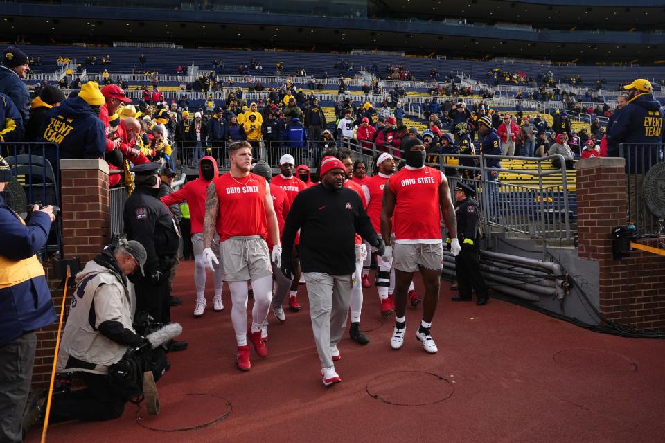 Nov 25, 2023; Ann Arbor, Michigan, USA; Ohio State Buckeyes defensive line coach Larry Johnson leads his players onto the field prior to the NCAA football game against the Michigan Wolverines at Michigan Stadium.