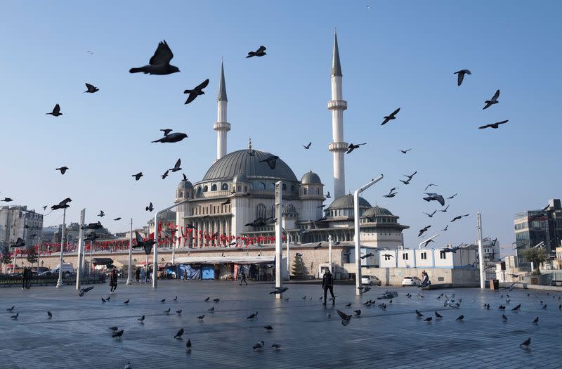 Pigeons fly over the Taksim Square during a nation-wide weekend curfew in Istanbul