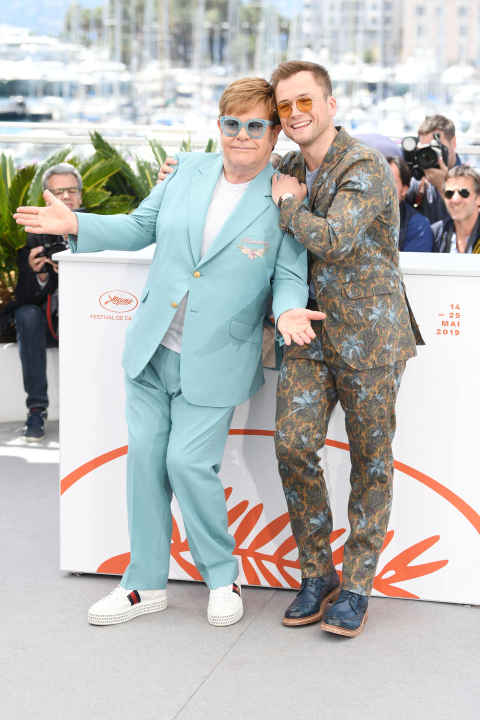 Elton wears Gucci and Taron wears Etro. [Photo: Getty