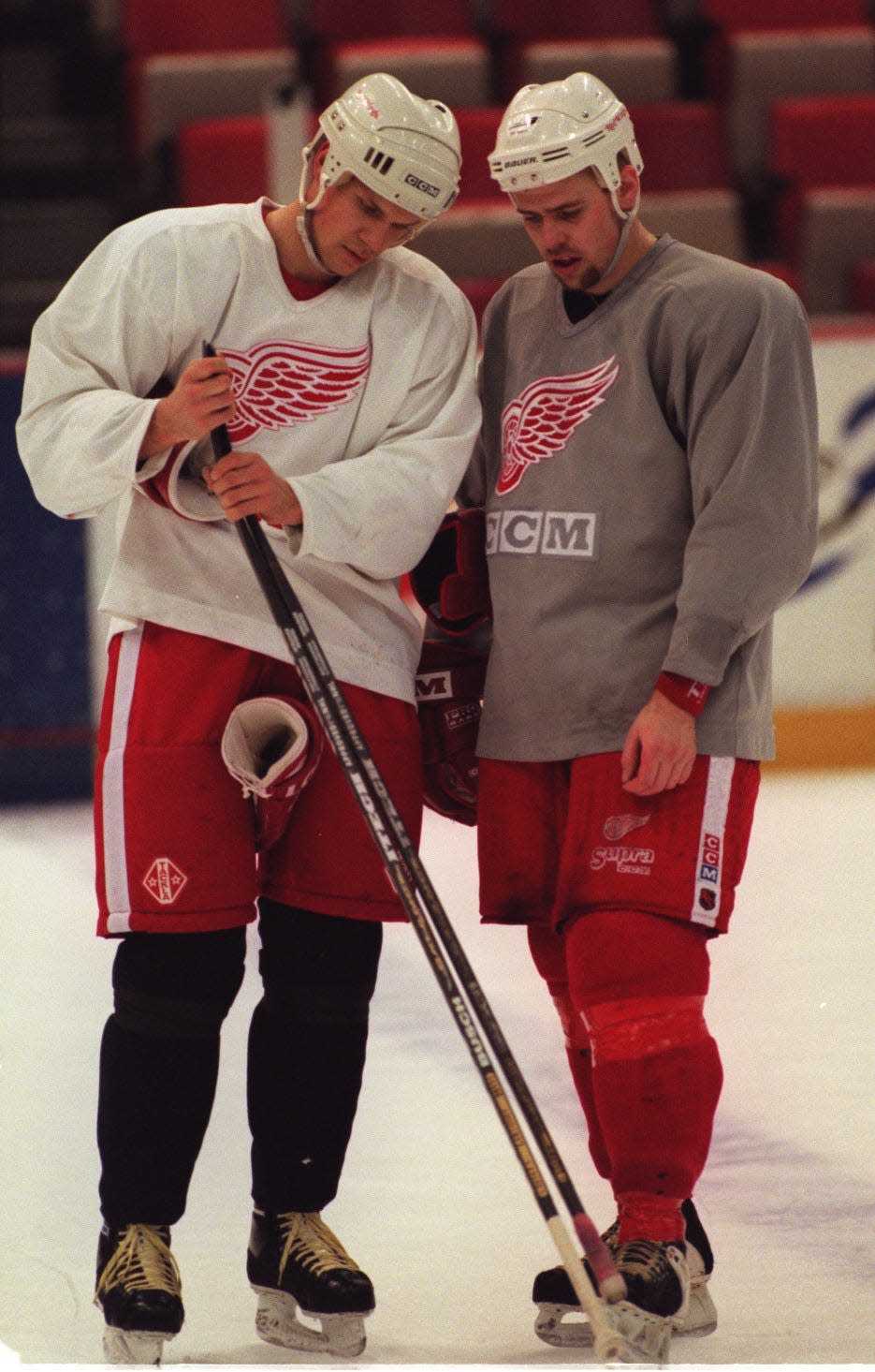 (left to right) Nicklas Lidstrom and Tomas Holmstrom compare each other's sticks during practice at Joe Louis Arena.  detroit free press photo by Mary Schroeder 5/1/97