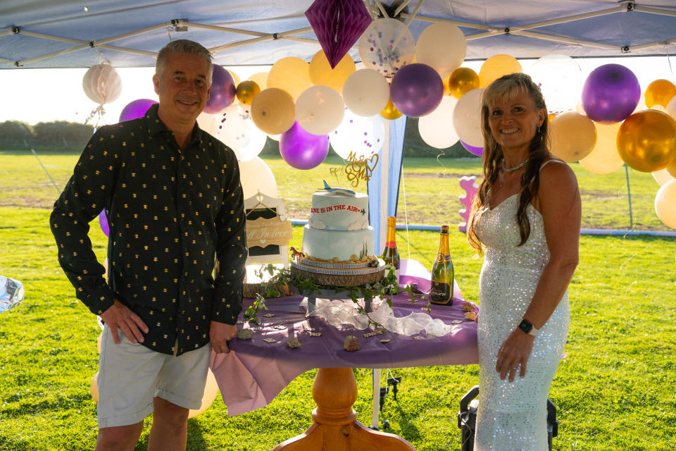 The couple with their plane-themed cake, complete with the words ‘Love is in the air’ (Tom Hall/Tui/PA)