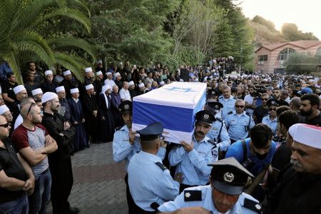 Israeli police officers carry the flag-drapepd coffin of Druze police officer Kamil Shanan during his funeral in the village of Hurfeish, Israel July 14 2017. REUTERS/Ammar Awad