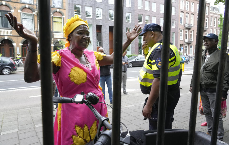 A woman argues with a police officer to attend a nationally televised annual ceremony, closed for coronavirus related measures, in Amsterdam, Netherlands, Thursday, July 1, 2021. The ceremony and and celebration known as Keti Koti, which means Chains Broken, marks the abolition of slavery in its colonies in Suriname and the Dutch Antilles on July 1, 1863. Debate about Amsterdam's involvement in the slave trade has been going on for years and gained attention last year amid the global reckoning with racial injustice that followed the death of George Floyd in Minneapolis last year. (AP Photo/Peter Dejong)