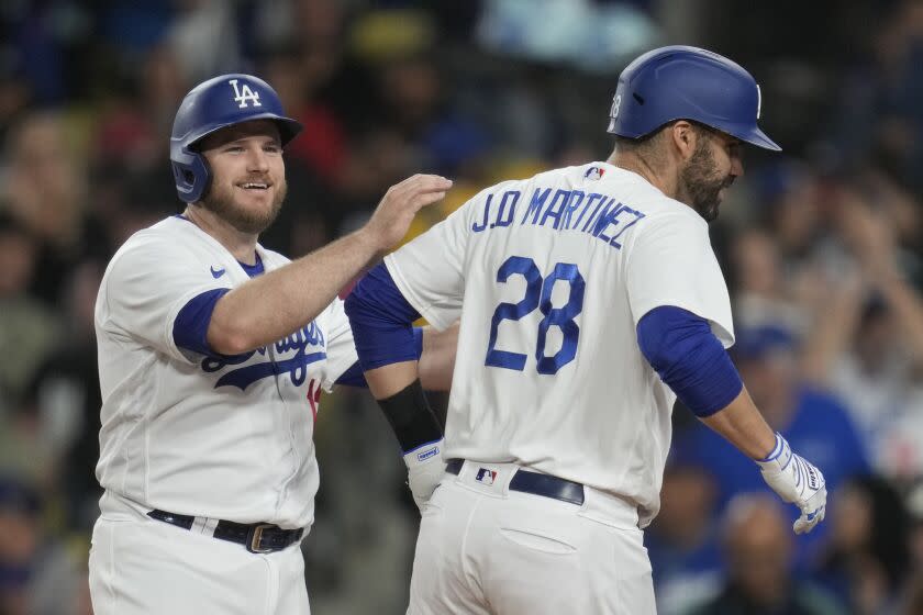 Los Angeles Dodgers' Max Muncy (13) celebrates with designated hitter J.D. Martinez.