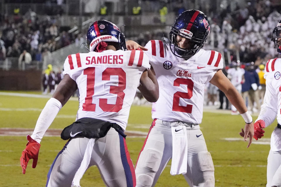 Mississippi quarterback Matt Corral (2) celebrates his second-half, 4-yard touchdown run with wide receiver Braylon Sanders (13) during an NCAA college football game against Mississippi State, Thursday, Nov. 25, 2021, in Starkville, Miss. Mississippi won 31-21. (AP Photo/Rogelio V. Solis)