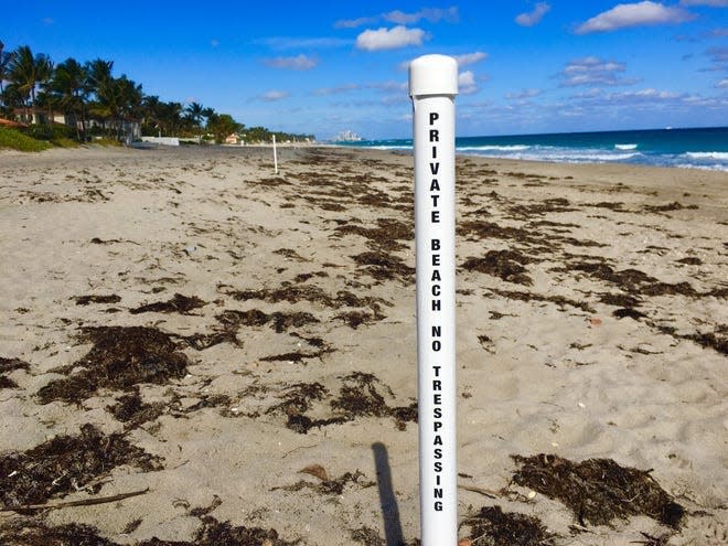 Posts in the sand at a beach in Palm Beach denote private beach ownership to the landward side of the post and public access to the ocean side.