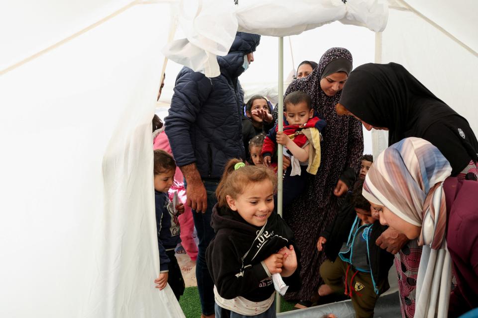 Palestinian children wait to be checked for malnutrition at a medical tent set up by MedGlobal in cooperation with Unicef, amid the ongoing conflict between Israel and the Palestinian Islamist group Hamas, in Rafah, in the southern Gaza Strip, 14 February 2024 (REUTERS)