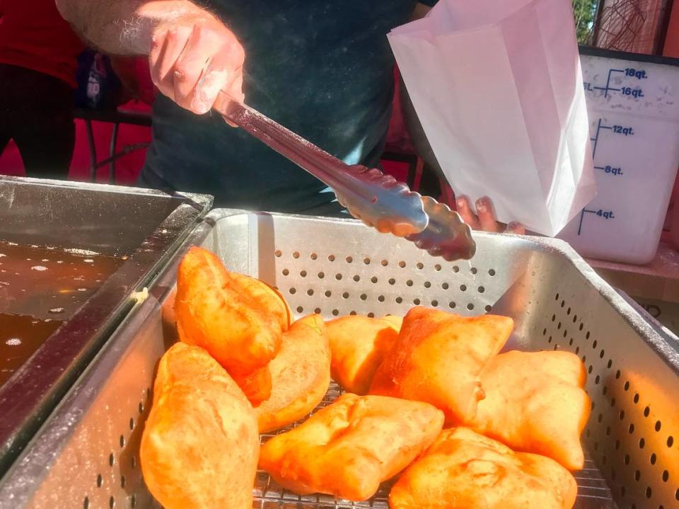 The Second Line owner David Perlis puts fresh, hot New-Orleans-style beignets in a bag at the Cambria Farmers Market. Perlis discovered June 19, 2022, that a trailer holding the equipment he uses for the business had been stolen.