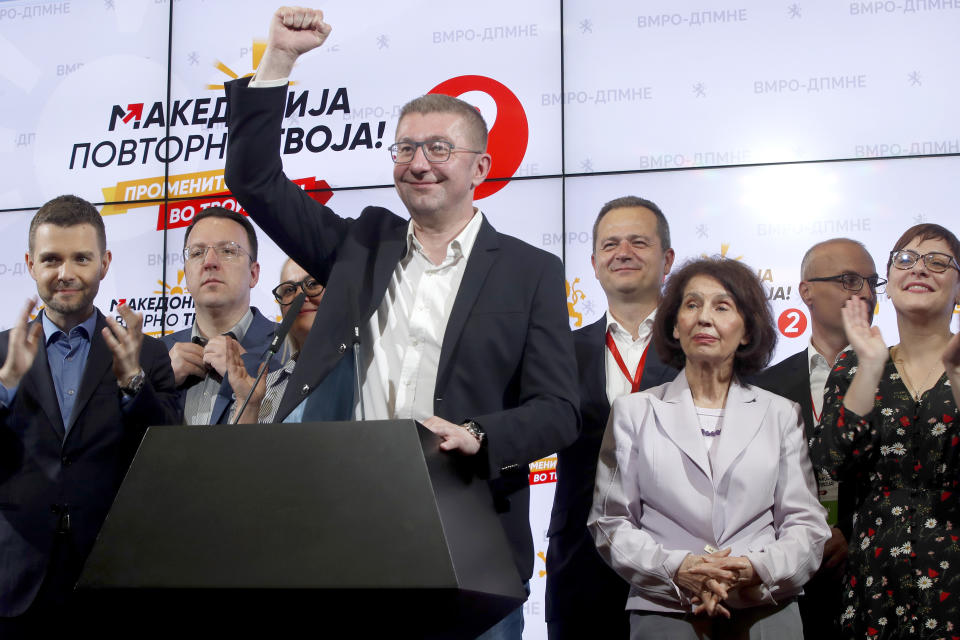 Hristijan Mickoski, center left, the leader of the opposition conservative VMRO-DPMNE party, raises his fist next to their presidential candidate Gordana Siljanovska Davkova, center right, during a news conference, after winning in the first round of the presidential election, in Skopje, North Macedonia, late Wednesday, April 24, 2024. Siljanovska Davkova has a big lead ahead of Stevo Pendarovski, the candidate of the Social Democrats and they both will face each other in the second round of the presidential election that will coincide with the general election on May 8. (AP Photo/Boris Grdanoski)