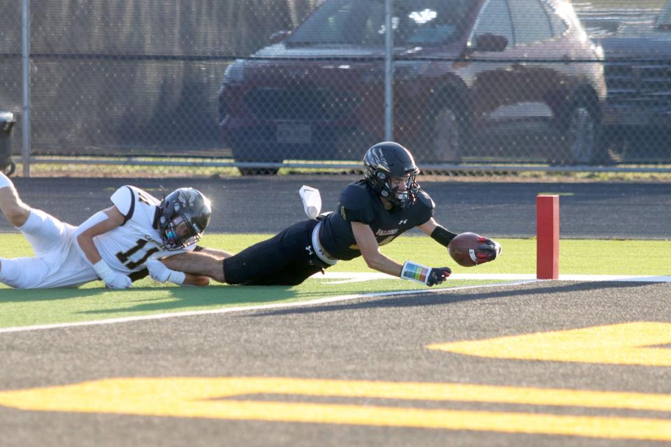 Bushland's Cole Purcell (14) stretches for a touchdown as Canadian faces Bushland in a football game, Friday, Sept. 2, 2022, at Falcon Stadium in Bushland. 
