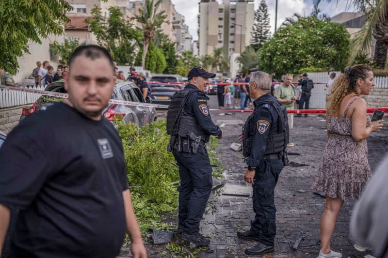 Security forces stand infront of damaged buildings in Kiryat Bialik, following a reported strike by the pro-Iranian Hezbollah movement. Ilia Yefimovich/dpa