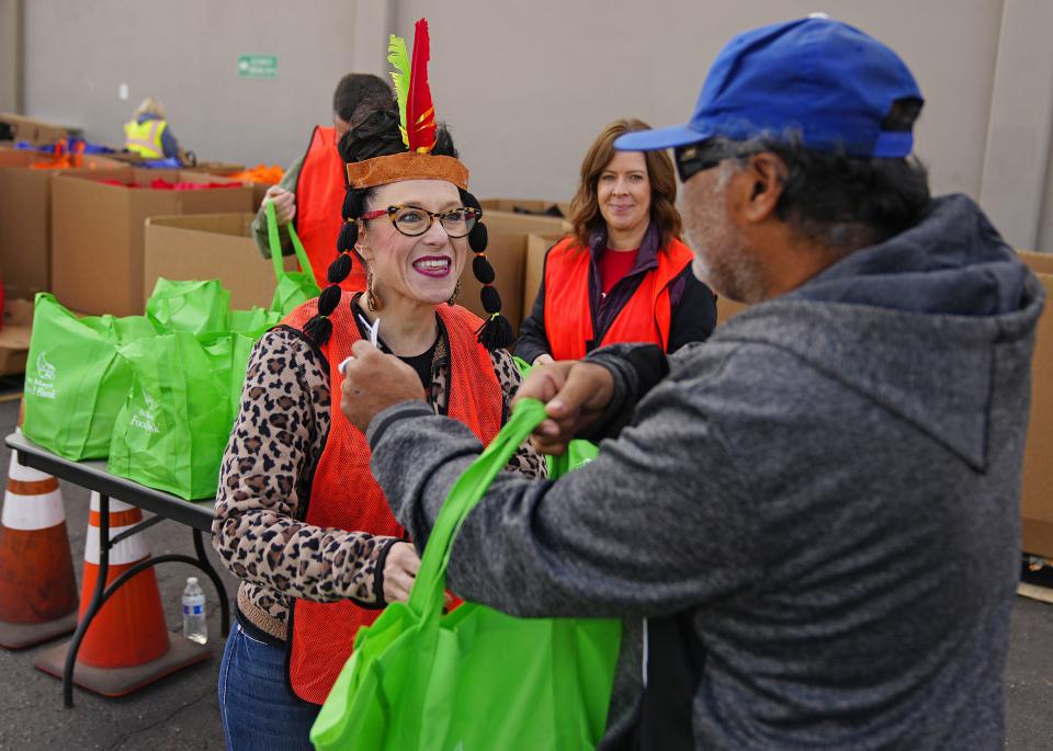 Mickaline Shroyer passes out a bag of food during an annual Thanksgiving food distribution at St. Mary's Food Bank on Nov. 22, 2022.