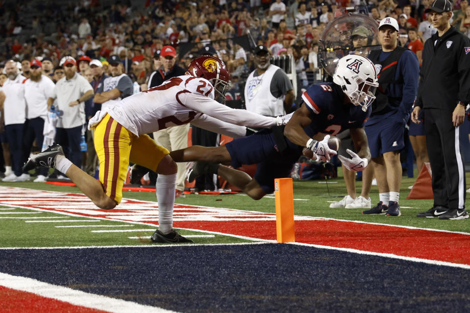 TUCSON, ARIZONA – OCTOBER 29: Wide receiver Jacob Cowing #2 of the <a class="link " href="https://sports.yahoo.com/ncaaw/teams/arizona/" data-i13n="sec:content-canvas;subsec:anchor_text;elm:context_link" data-ylk="slk:Arizona Wildcats;sec:content-canvas;subsec:anchor_text;elm:context_link;itc:0">Arizona Wildcats</a> scores on a two point conversion attempt while being tackled by defensive back Bryson Shaw #27 of the USC Trojans during the second half at Arizona Stadium on October 29, 2022 in Tucson, Arizona. (Photo by Chris Coduto/Getty Images)