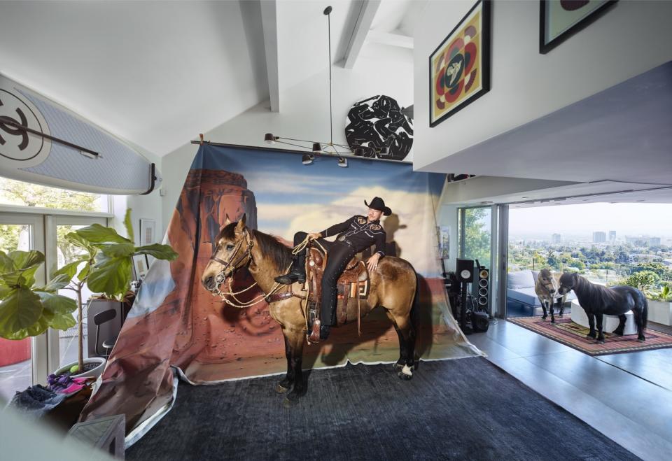 DJ and producer Diplo is photographed by Jim Krantz atop a live horse inside his Beachwood Canyon home.