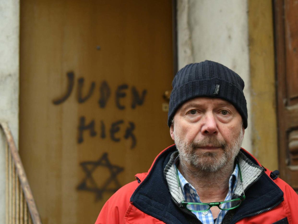 Aldo Rolfi poses for photographs in front of his home in Mondovi, which was defaced by antisemitic graffiti: EPA