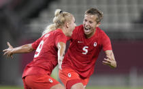 Canada's Adriana Leon, left, celebrates with teammate Quinn after scoring her side's opening goal against Great Britain during a women's soccer match at the 2020 Summer Olympics, Tuesday, July 27, 2021, in Kashima, Japan. (AP Photo/Fernando Vergara)