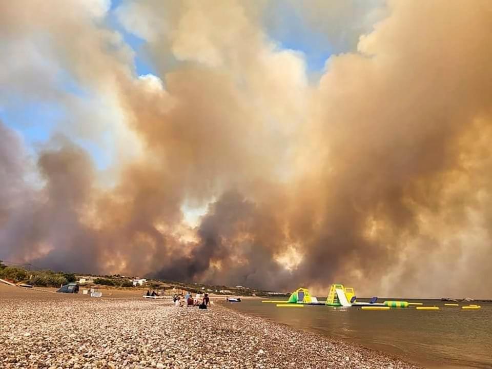 Clouds of smoke from a forest fire rise to the sky on the island of Rhode