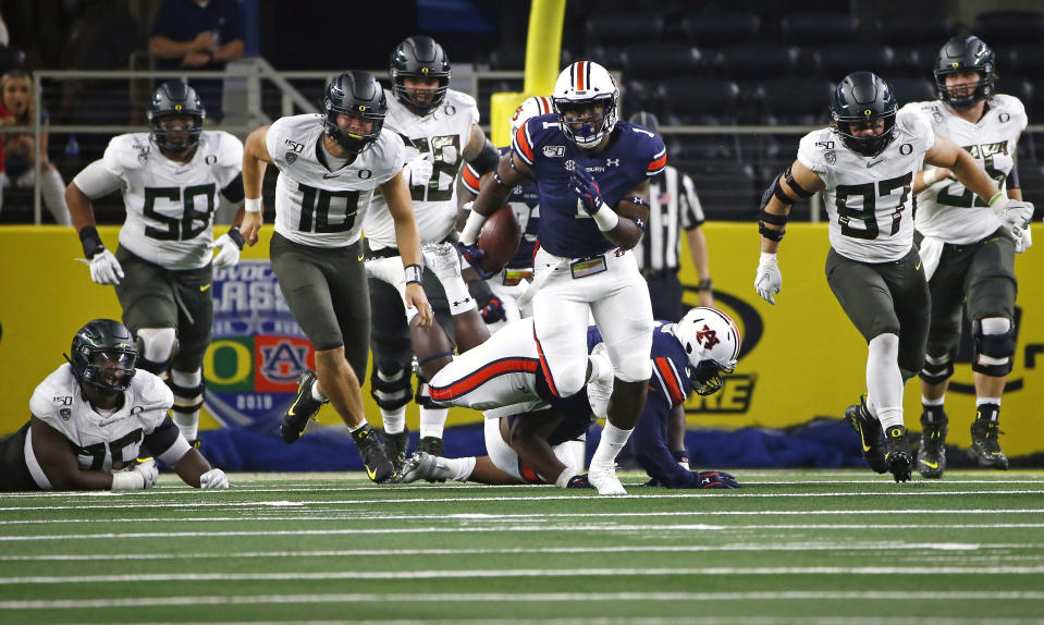 Auburn defensive end Big Kat Bryant (1) returns a fumble as Oregon quarterback Justin Herbert (10) and others pursue him during the first half of an NCAA college football game, Saturday, Aug. 31, 2019, in Arlington, Texas. (AP Photo/Ron Jenkins)