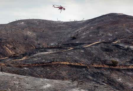 A fire helicopter flies over a charred hillside during the La Tuna Canyon fire over Burbank, California, September 3, 2017. REUTERS/ Kyle Grillot