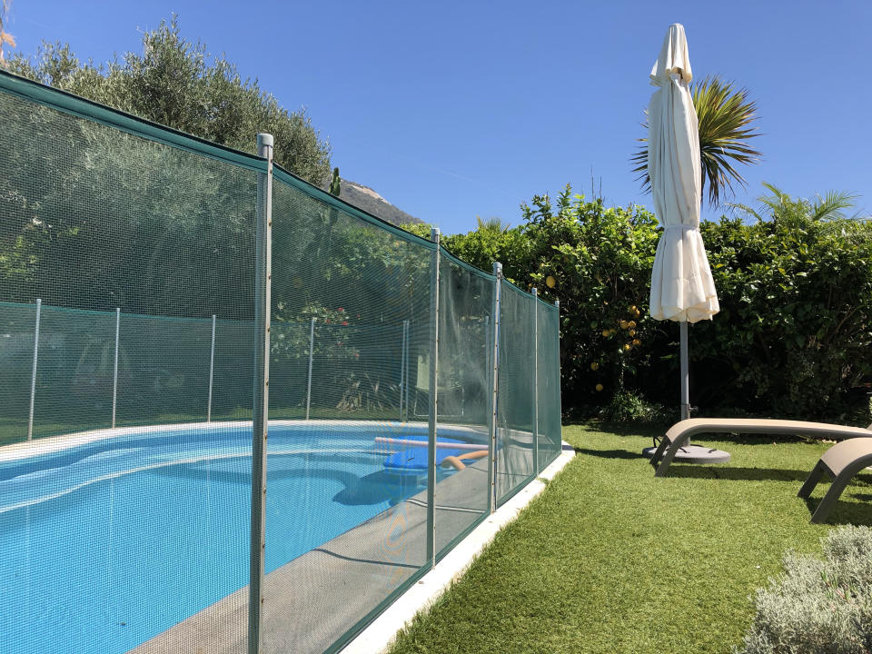 Home swimming pool in garden with safety fence