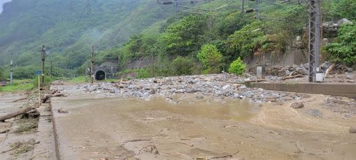 花蓮北區22日下午下大雨，省道台9線160.71K土石崩落、道路受阻，泥流也沖到台鐵北迴線，和仁車站至崇德車站間遭土石淹沒，目前鐵路局在搶修中斷的路線。（花蓮縣消防局提供）