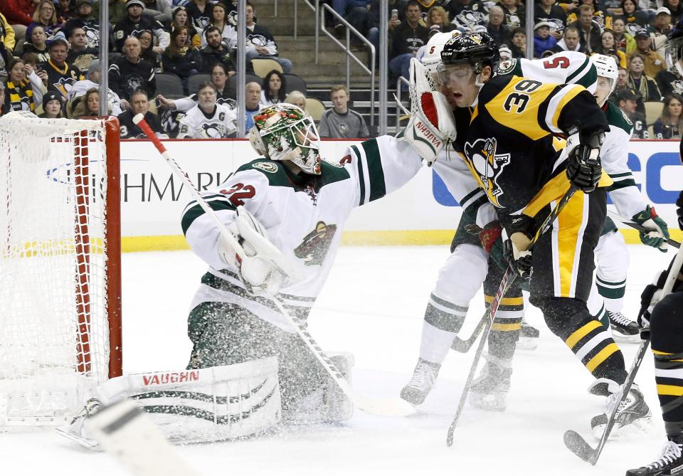 Jan 13, 2015; Pittsburgh, PA, USA; Minnesota Wild goalie Niklas Backstrom (32) hits Pittsburgh Penguins left wing David Perron (39) while making a save during the second period at the CONSOL Energy Center. The Penguins won 7-2. Mandatory Credit: Charles LeClaire-USA TODAY Sports