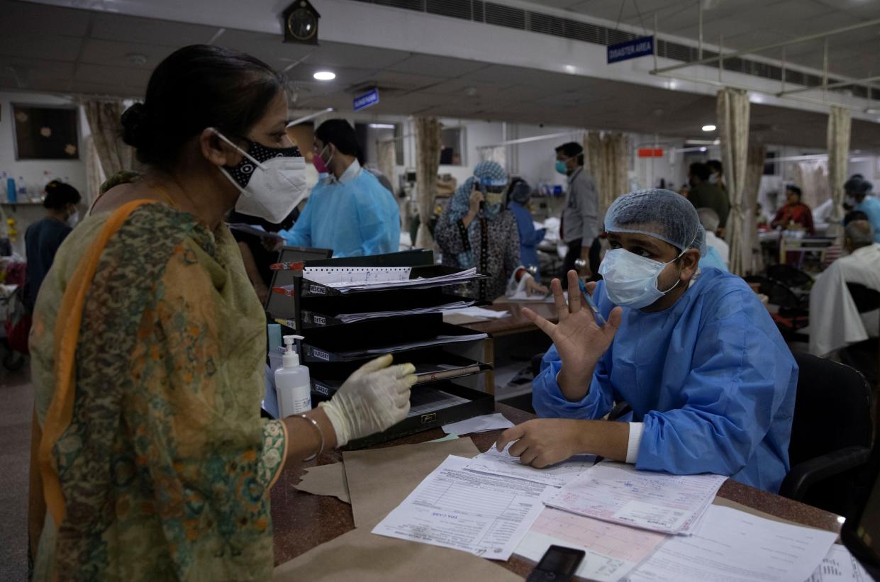 <p>Rohan Aggarwal, 26, a resident doctor treating patients suffering from coronavirus, talks to the relative of a Covid-19 patient about the unavailability of hopsital beds during his 27-hour shift at the Holy Family Hospital in New Delhi, India</p> (Reuters)