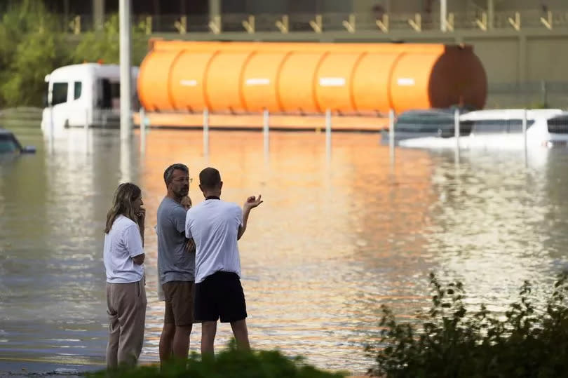 People look out at floodwater covering a major road in Dubai, United Arab Emirates -Credit:AP