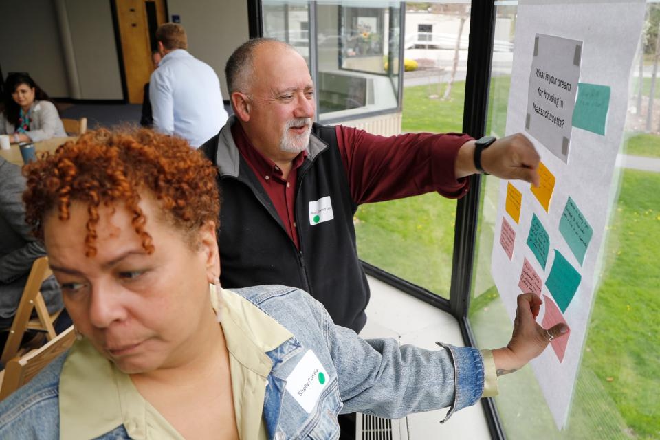 Shelly Correia, Director of the Harbor House, and Rev. David Lima, Executive Director of Inter-Church Council of Greater New Bedford, place their notes on the "What is your dream for housing in Massachusetts" during one of the fourteen regional listening sessions held at UMass Dartmouth, hosted by the Executive Office of Housing and Livable Communities.