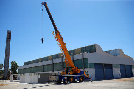 A worker drives a truck-mounted crane after placing makeshift emergency stalls for the preparations of the new Center for Temporary Assistance to Foreigners (CATE) at the port of Algeciras in San Roque, southern Spain, July 30, 2018. REUTERS/Jon Nazca