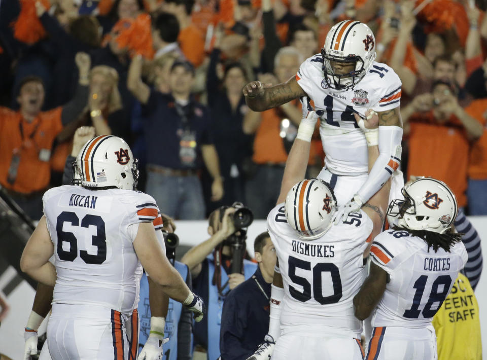 Auburn quarterback Nick Marshall is lifted by teammates after rushing for a touchdown during the first half of the NCAA BCS National Championship college football game against Florida State Monday, Jan. 6, 2014, in Pasadena, Calif. (AP Photo/Chris Carlson)