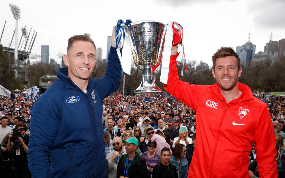 Seen here, Joel Selwood of the Cats and Luke Parker of the Swans pose with the Premiership Cup during the 2022 AFL grand final parade. 