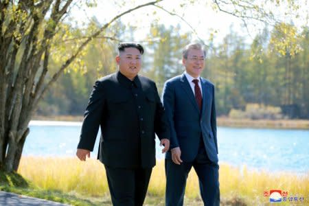 FILE PHOTO - South Korean President Moon Jae-in and North Korean leader Kim Jong Un walk during a luncheon, in this photo released by North Korea's Korean Central News Agency (KCNA) on September 21, 2018. KCNA via REUTERS