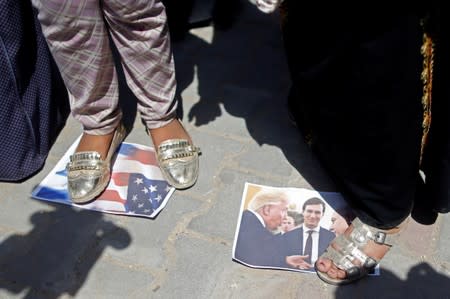 Palestinian woman steps on a picture of U.S. President Trump, Israeli PM Netanyahu and White House senior adviser Kushner during a protest in Gaza City