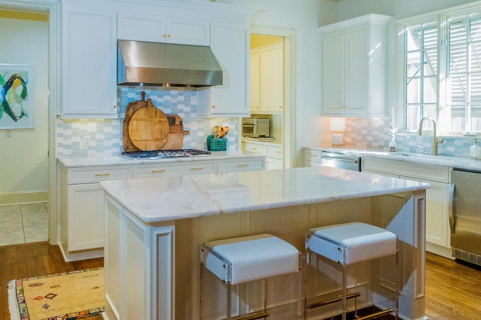 The kitchen utilizes white cabinetry and stainless steel appliances for a clean look and feel.