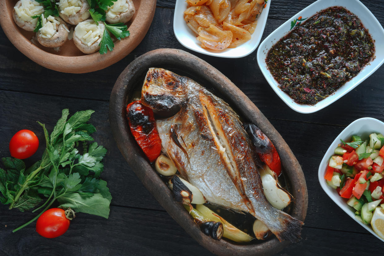 Fresh fish on a black wooden board. Raw uncooked sea bream on black plate.