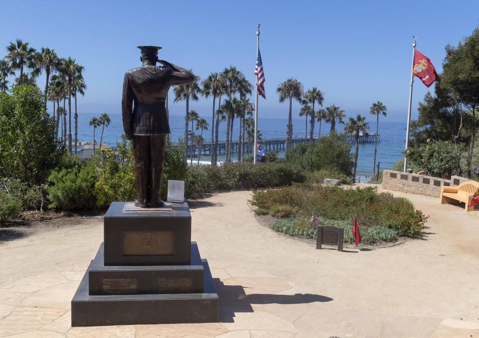 Former San Clemente Mayor Wayne Eggleston lowers the U.S. flag to half-staff at Park Semper Fi in San Clemente, Calif., on Friday, July 31, 2020. Officials say a military seafaring assault vehicle with 15 Marines and a Navy sailor aboard sank off the coast of Southern California, leaving one of the Marines dead and eight missing. A Marine Corps spokesman says they were traveling in the amphibious assault vehicle from the shores of San Clemente Island to a Navy ship Thursday evening when they reported that the vehicle was taking on water. (Paul Bersebach/The Orange County Register via AP)