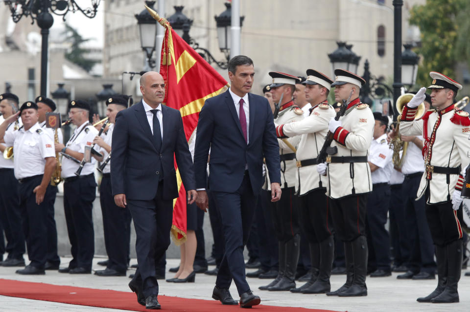 Spain's Prime Minister Pedro Sanchez, center and North Macedonia's Prime Minister Dimitar Kovacevski, left, walk next to an honor guard squad, during a ceremony upon his arrival at the government building in Skopje, North Macedonia, on Sunday, July 31, 2022. Spanish Prime Minister Pedro Sanchez is on a one-day official visit to North Macedonia as a part of his Western Balkans tour. (AP Photo/Boris Grdanoski)