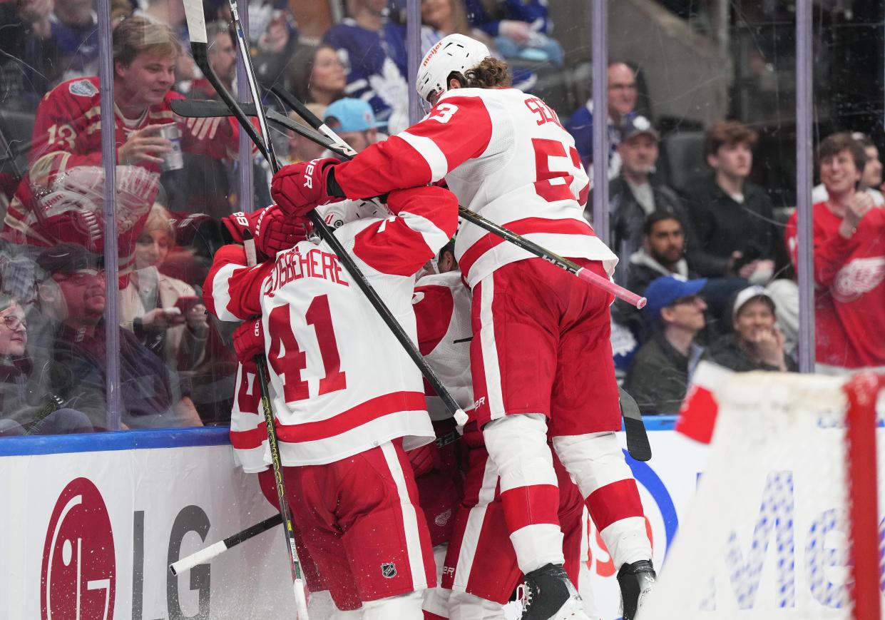 Red Wings defenseman Moritz Seider celebrates the win with defenseman Shayne Gostisbehere (41) during the overtime period of the Red Wings' 5-4 win on Saturday, April 13, 2024, in Toronto.