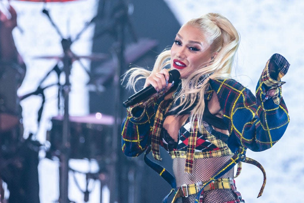 gwen stefani performing in plaid and fishnet outfit